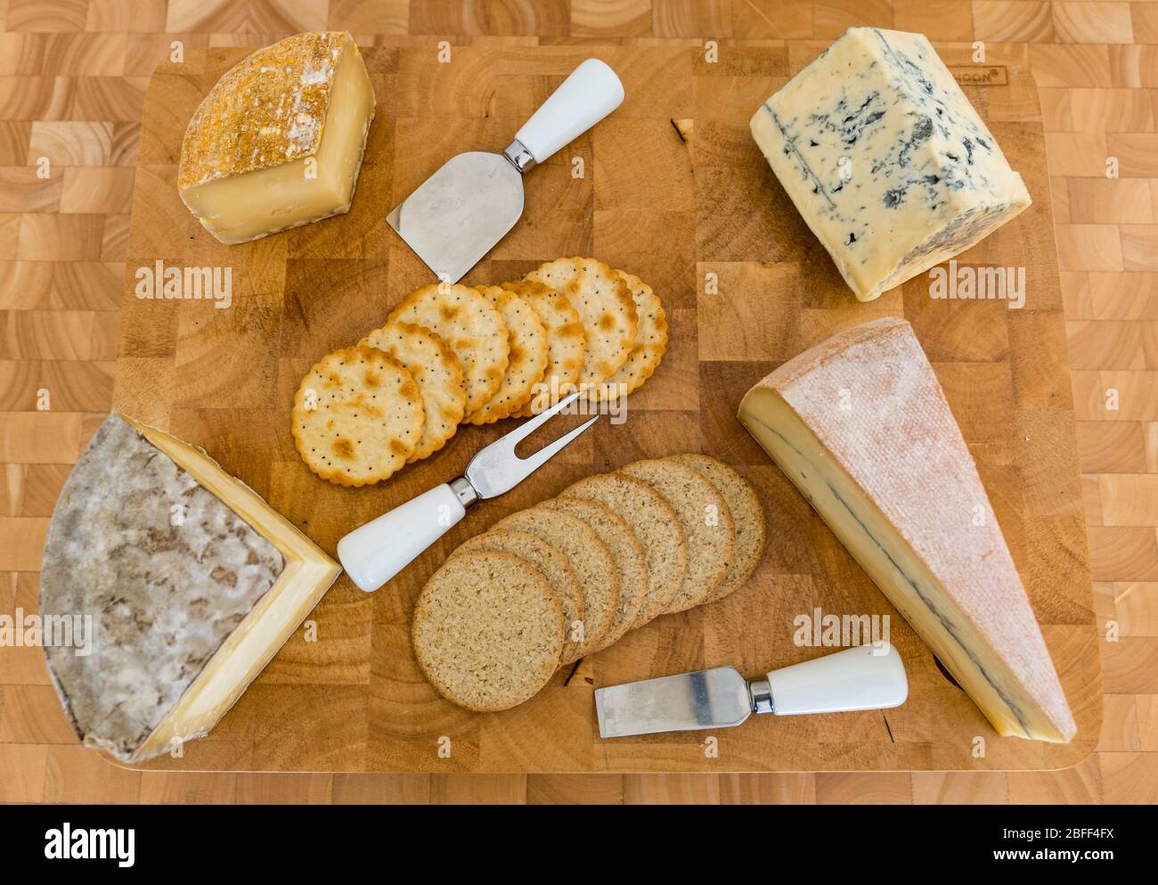 Cheeseboard: artisan cheeses Gorwydd Caerphilly (Wales), Sheep Rustler (Somerset), Cashel Blue cheese (Ireland) & Morbier (France) crackers & oatcakes Stock Photo