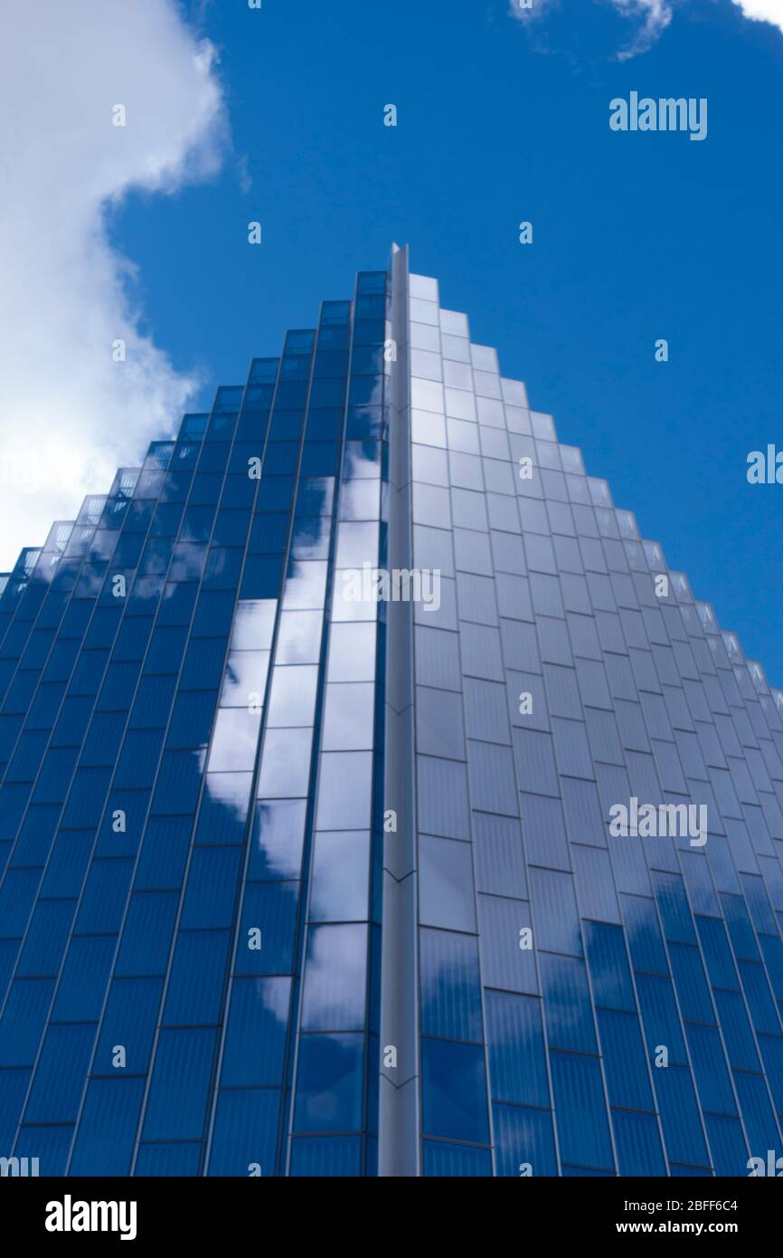 Abstract architecture reflections and angles set against a blue sky framed for geometry Stock Photo