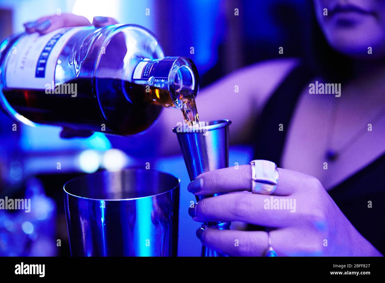 Bartender Pours Red Liquid From Jigger Into Mixing Cup Stock Photo