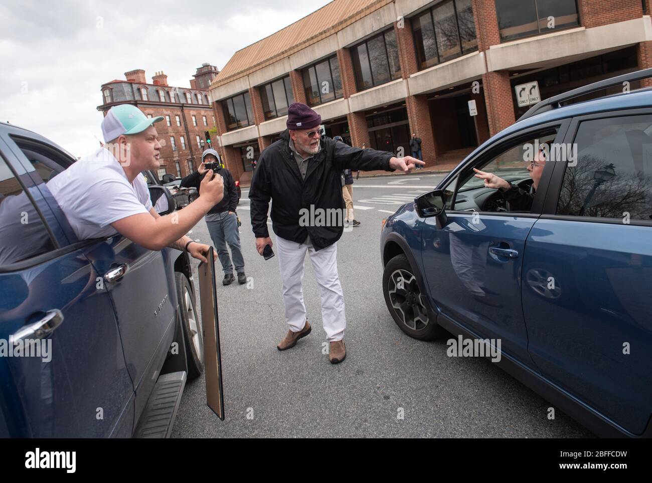 Annapolis, United States. 18th Apr, 2020. Protesters and counter protester argue during a car protest to reopen Maryland and end the stay at home order imposed during the Coronavirus COVID-19 pandemic, near the state capitol building in Annapolis, Maryland on Saturday, April 18, 2020. Drivers circled Annapolis hoking their horns and calling for Gov. Larry Hogan (R-MD) to end the stay at home order. Photo by Kevin Dietsch/UPI Credit: UPI/Alamy Live News Stock Photo