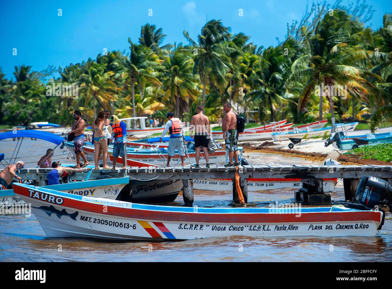 Tourists and boats in the beach in Punta Allen Sian Ka'an Reserve, Yucatan Peninsula, Mexico.  In the language of the Mayan peoples who once inhabited Stock Photo