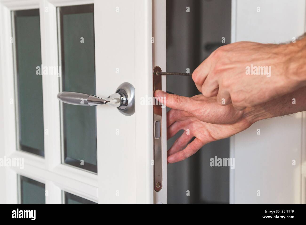 Male handyman carpenter at interior wood door lock installation Stock ...