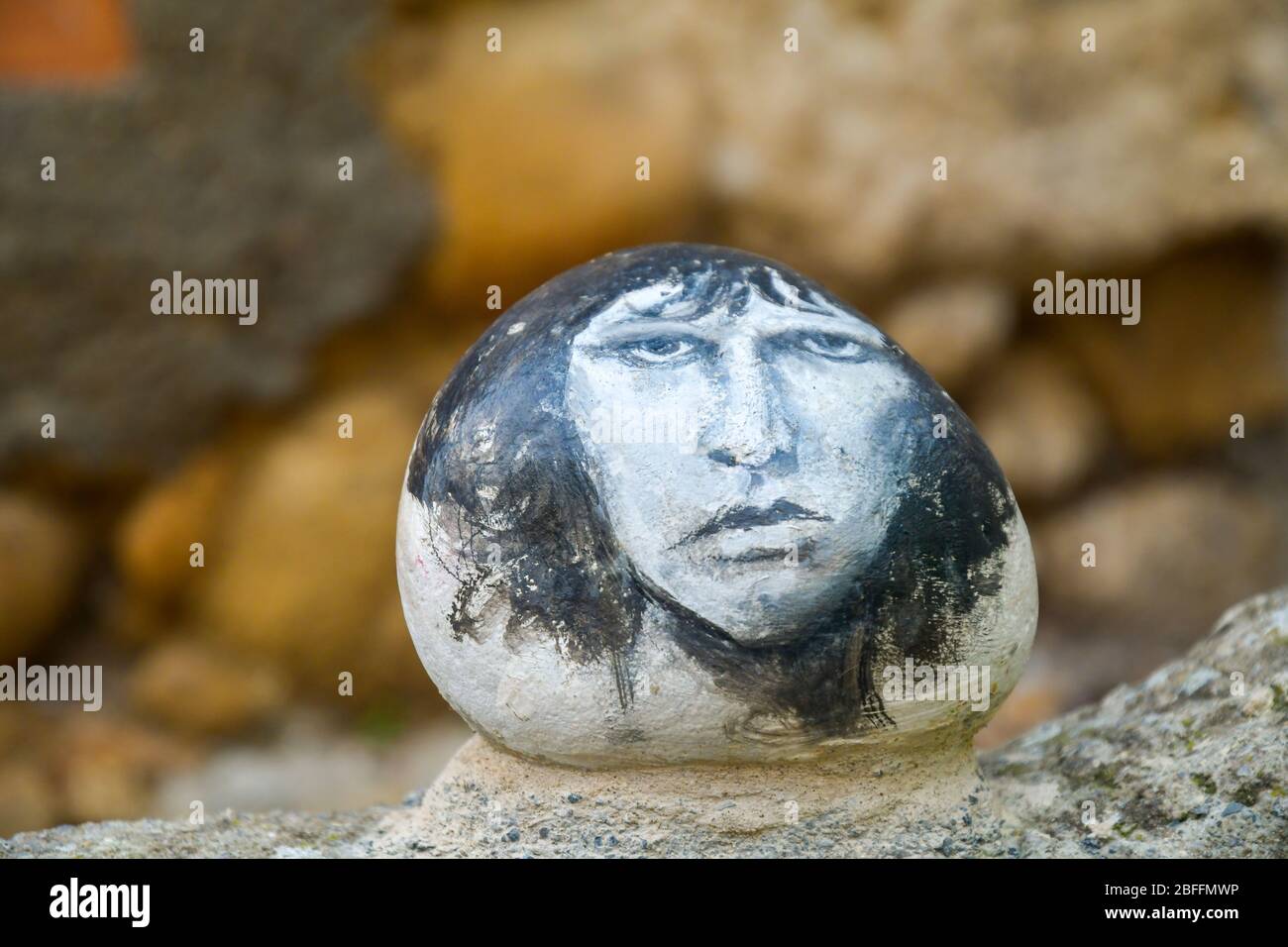Close-up of a hand-painted stone with the portrait of Jim Morrison, lead vocalist of the rock band the Doors, Bussana Vecchia, Imperia, Liguria, Italy Stock Photo