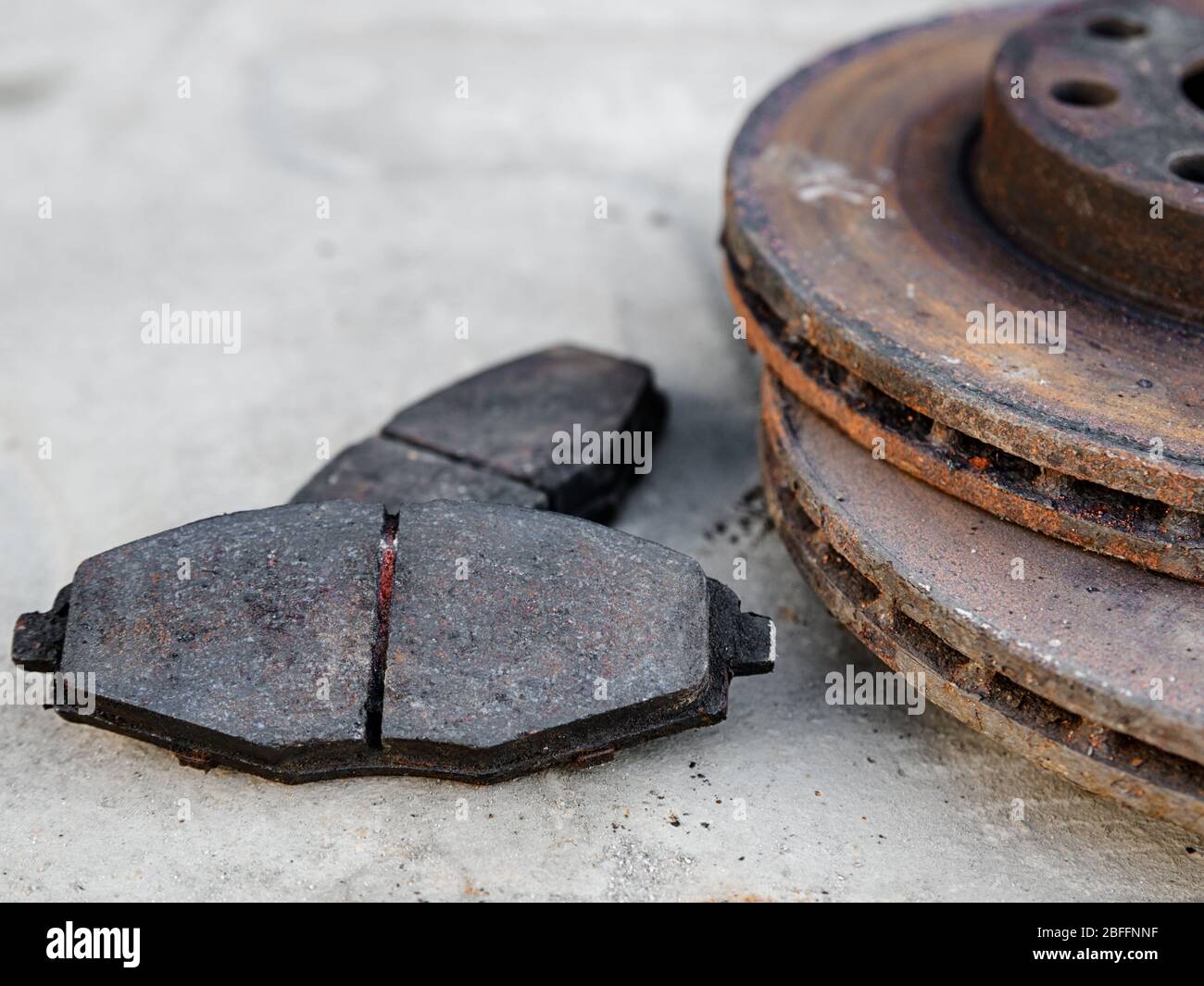 old worn car brake pads with brake discs at shallow depth of field