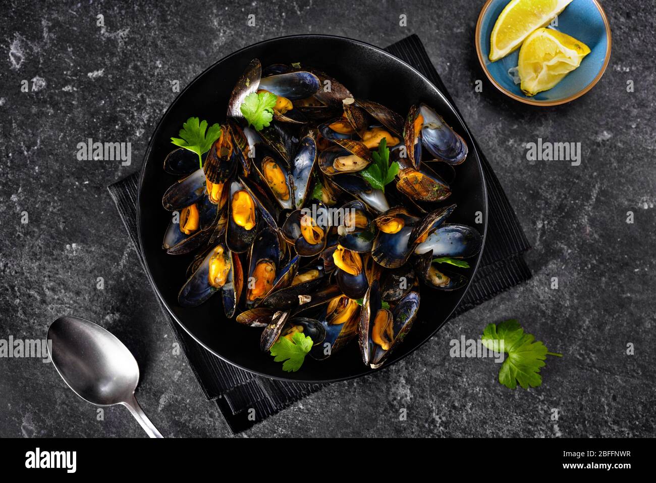 Close up of a black plate with mussels on black background Stock Photo
