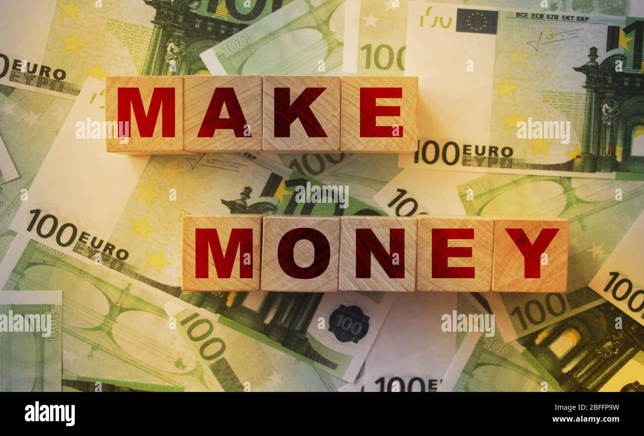 Make money words on Wooden Blocks put on 100 Euro bills. Making profit successful business concept Stock Photo