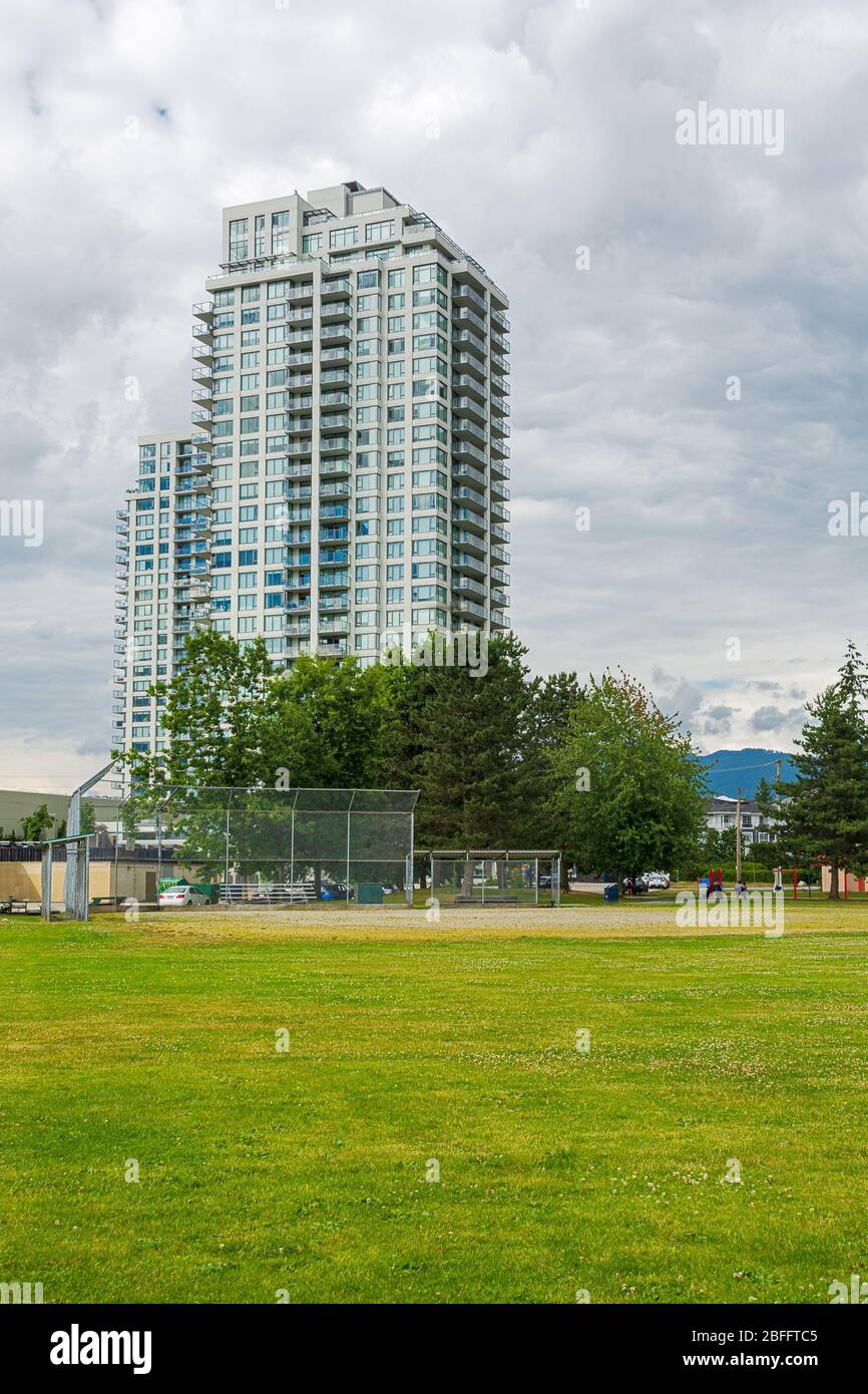 Picture of New residential high-rise buildings with green lawn of park in front ...