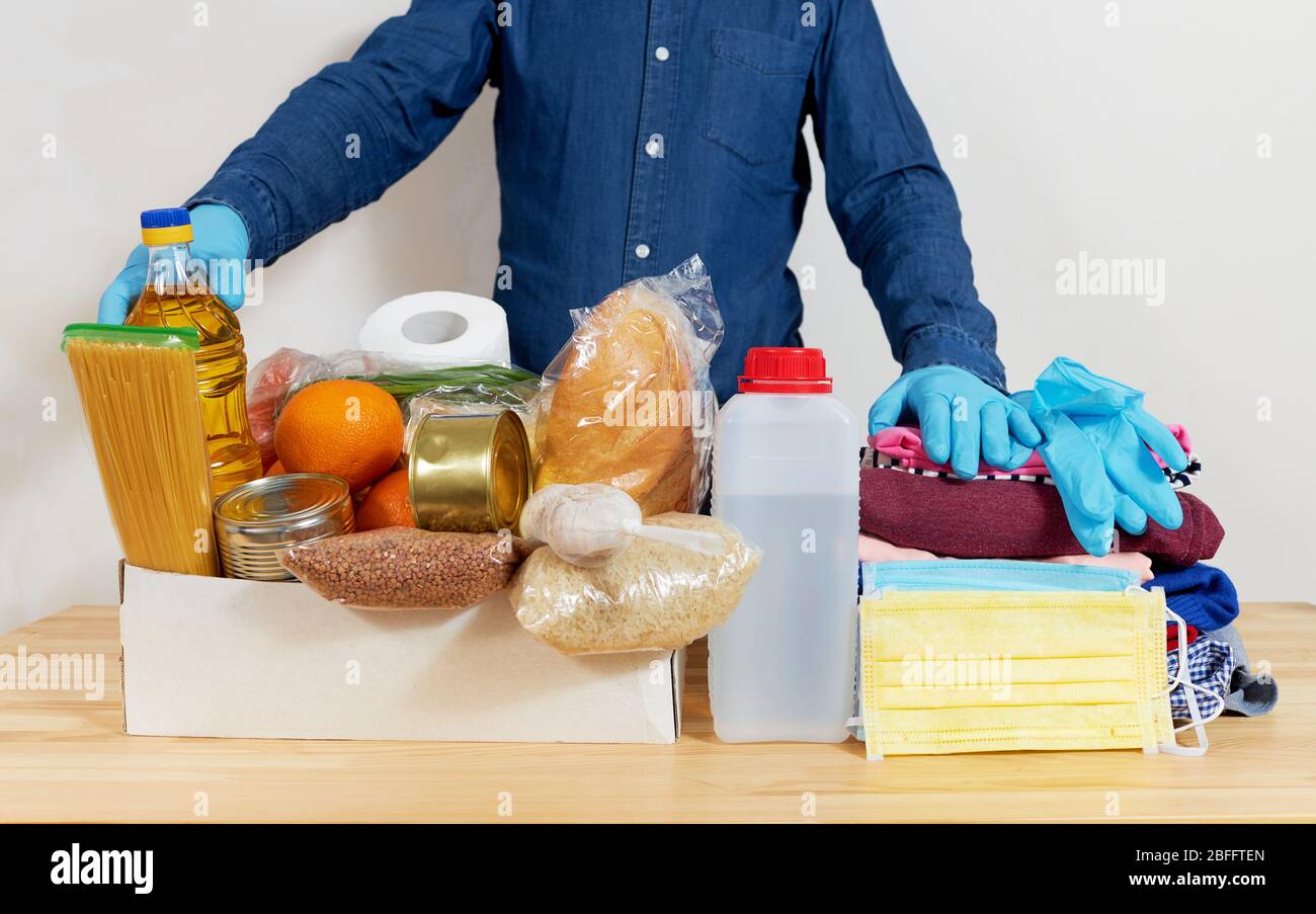 Mens hands hold Quarantine donation box. Food, clothing and personal