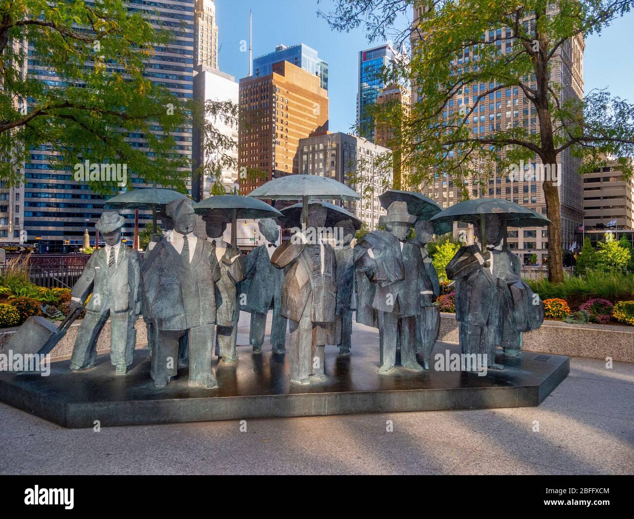 The Living World Series Gentlemen Statue by Taiwanese sculptor Ju Ming This artwork is prominently displayed on the Chicago AMA Plaza. The Gentlemen are part of Ju’s “Living World Series,” featuring eleven bronze plated figures draped in trench jackets and holding umbrellas. Blocky and minimalist, the figures are reduced to the basic forms intentionally to embrace the inner spiritual qualities within human bodies. Stock Photo