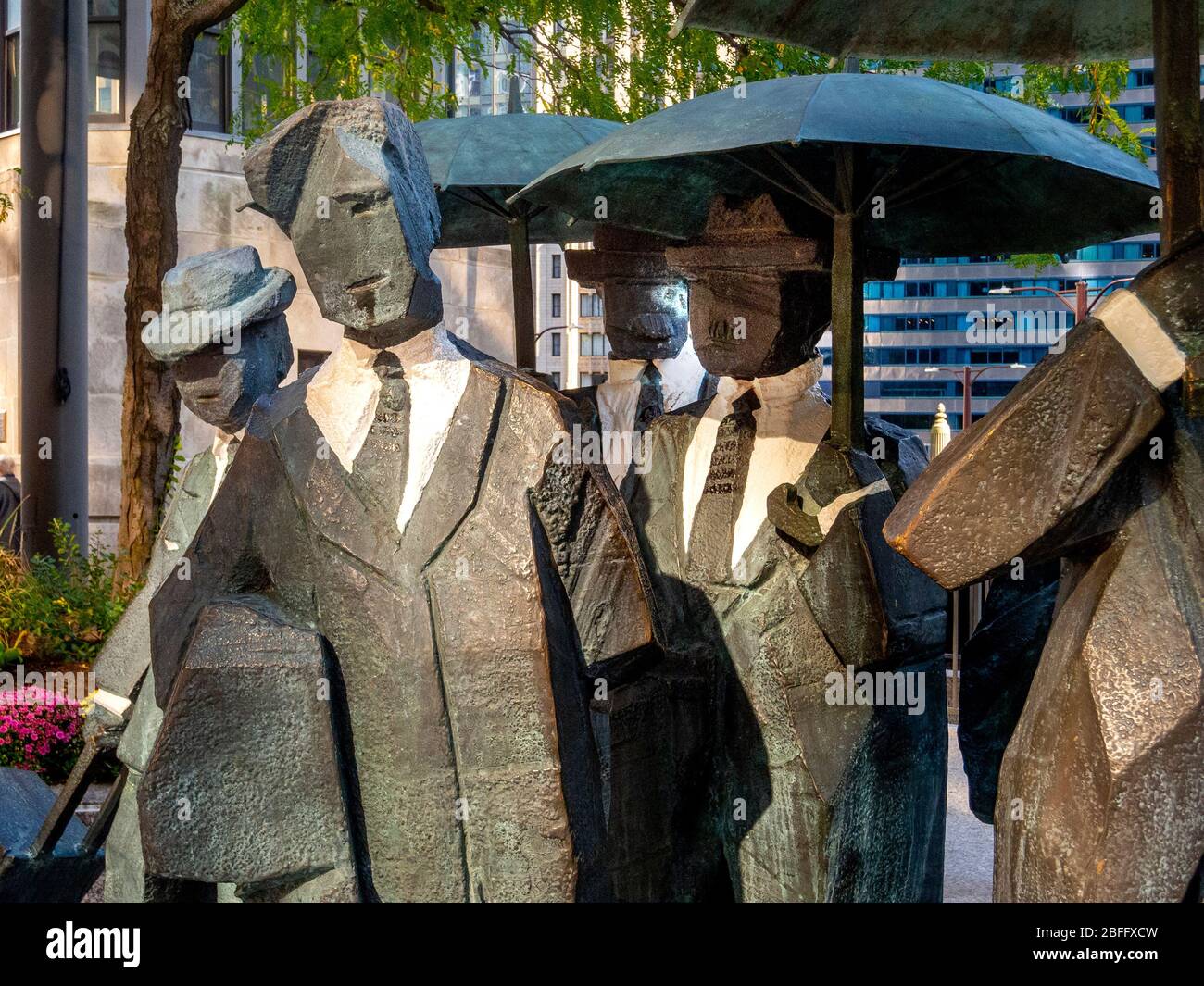 The Living World Series Gentlemen Statue by Taiwanese sculptor Ju Ming This artwork is prominently displayed on the Chicago AMA Plaza. The Gentlemen are part of Ju’s “Living World Series,” featuring eleven bronze plated figures draped in trench jackets and holding umbrellas. Blocky and minimalist, the figures are reduced to the basic forms intentionally to embrace the inner spiritual qualities within human bodies. Stock Photo