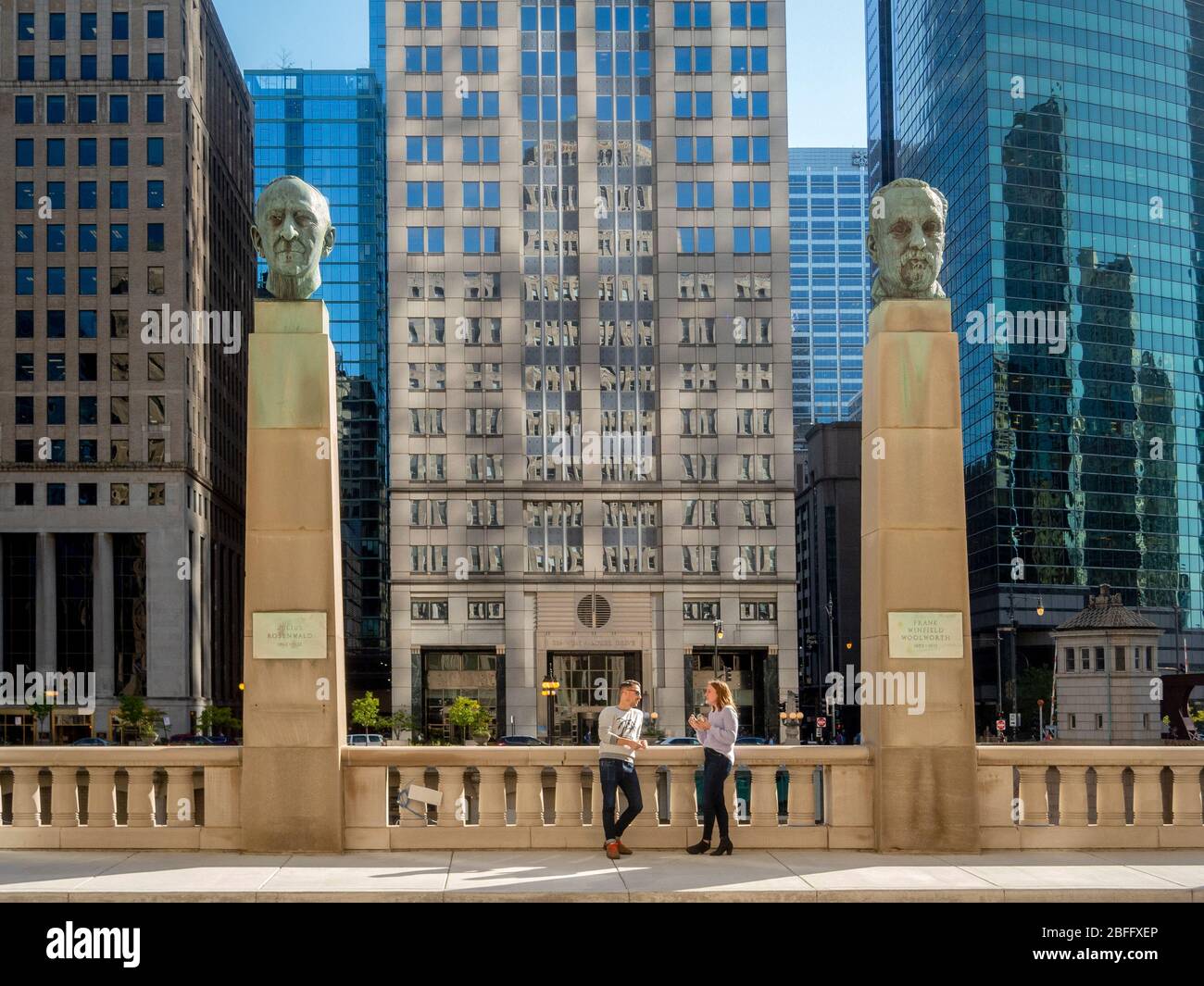 Portrait statues of famous businessmen  Julius Rosenwald and Frank Winfield Woolworth stand on columns before Chicago's Merchandise Mart on the Chicago River. Stock Photo