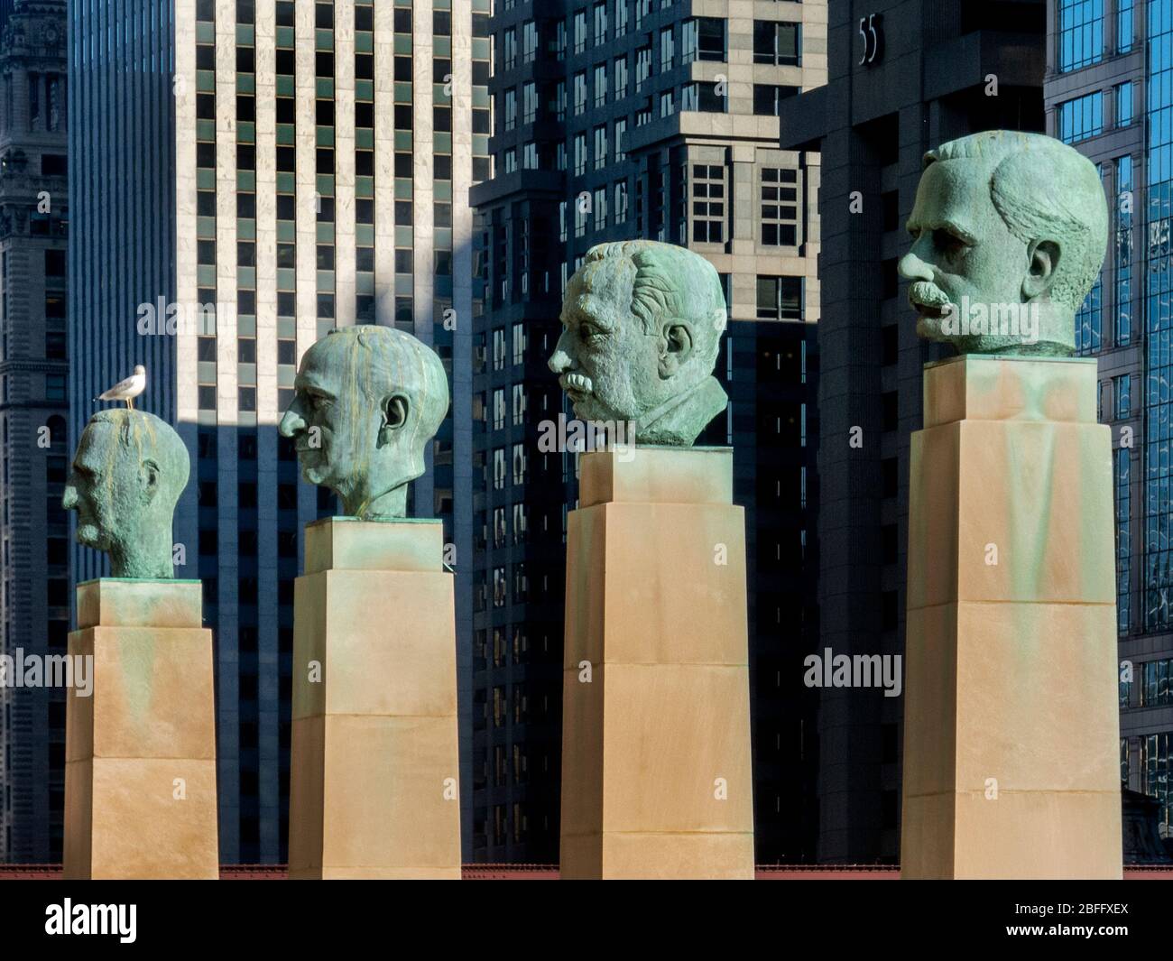 Portrait statues of famous businessmen Robert Wood, Julius Rosenwald, Frank Winfield Woolworth and Marshall Field stand on columns before Chicago's Merchandise Mart on the Chicago River. Stock Photo