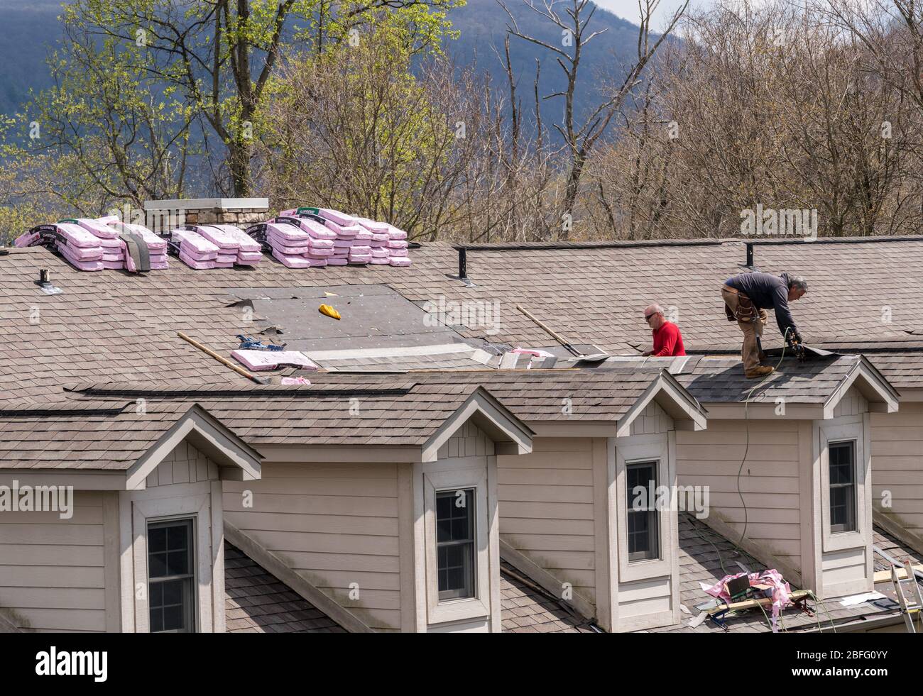Roofing Vorbereitung Asphaltschindeln Installation auf Haus Bau Holzdach  mit Bitumen Spray und Schutz Seil, Sicherheit Kit. Roofing constru  Stockfotografie - Alamy