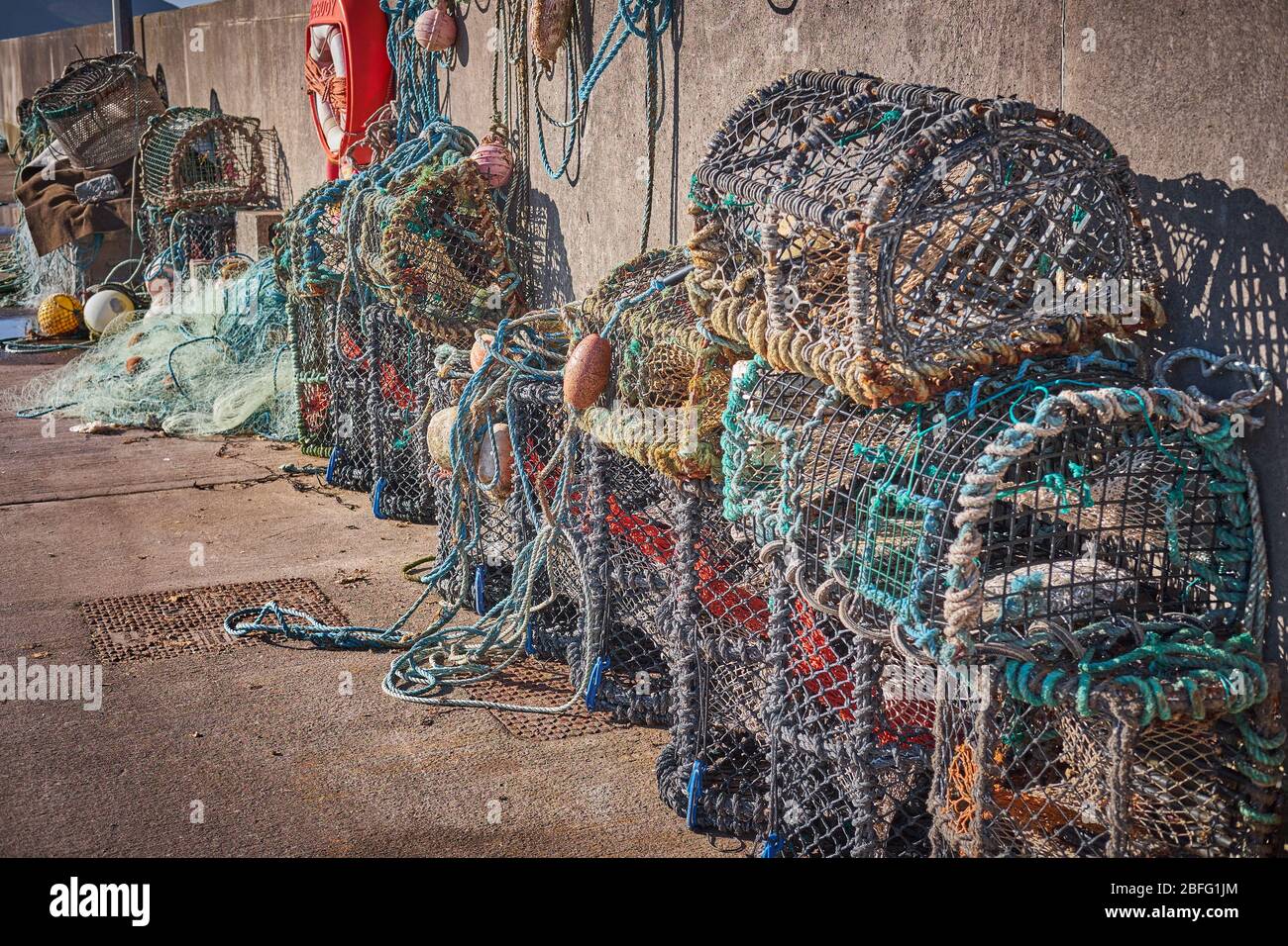 Lobster or crab fishing cages in colors stacked on a pier in the Dingle Peninsula, Ireland. Stock Photo