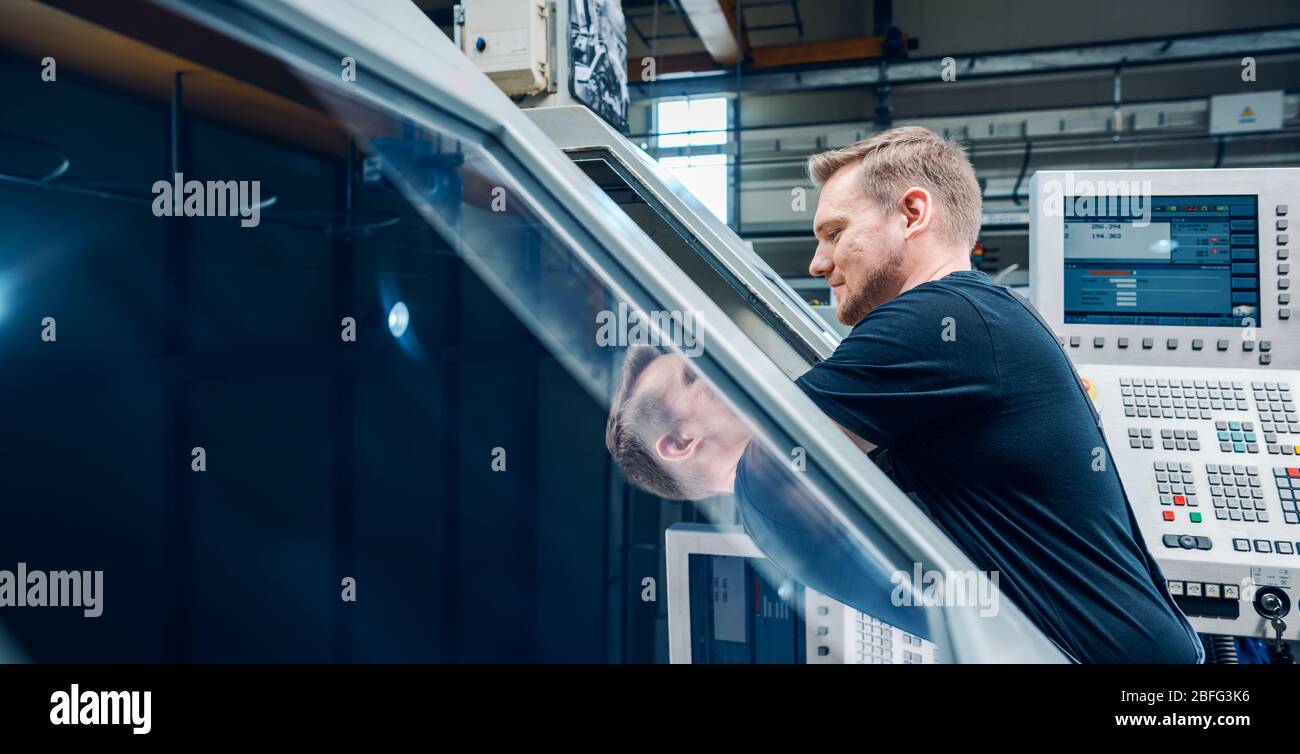 Worker resetting a cnc lathe machine in manufacturing factory Stock ...