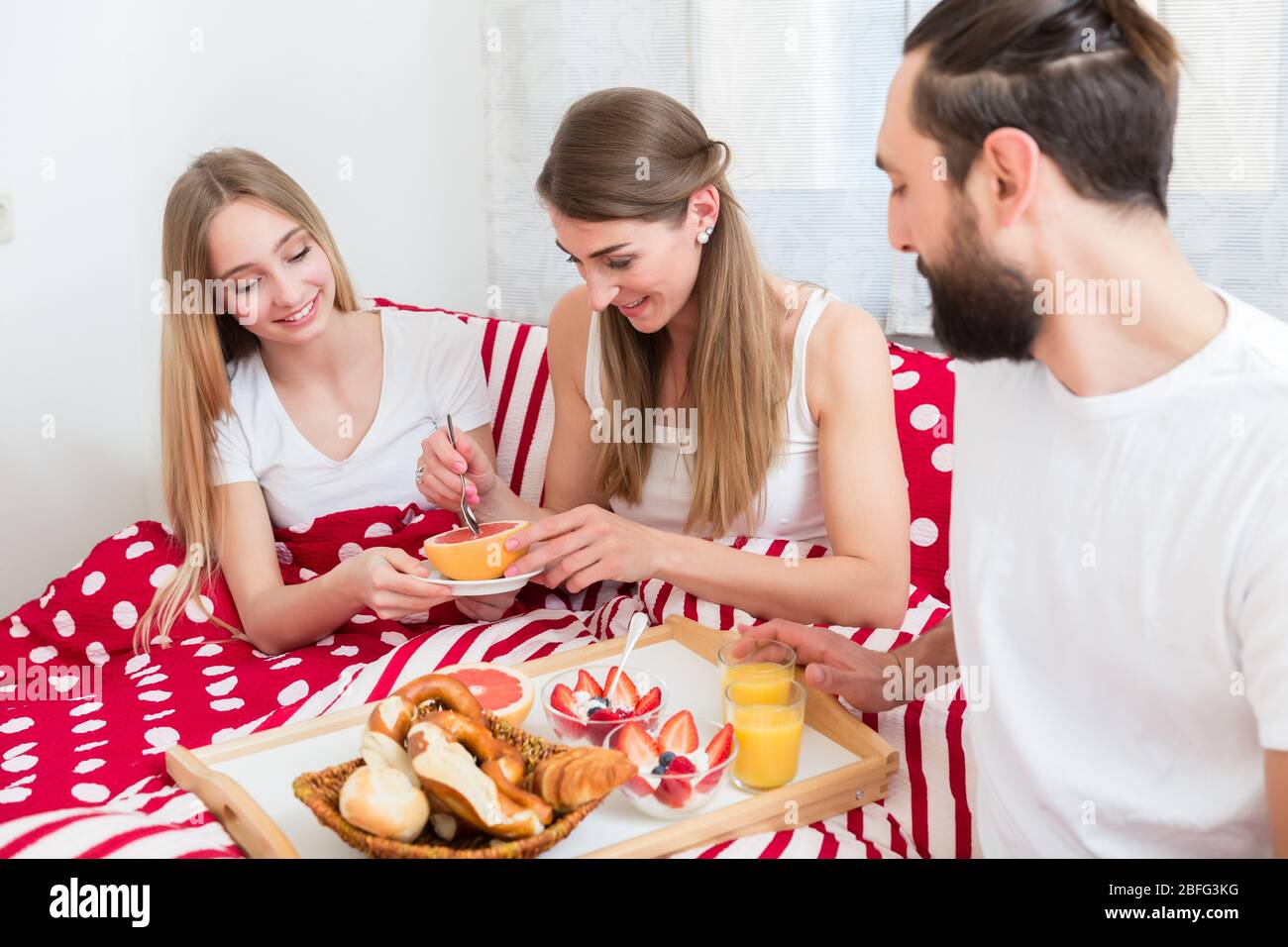 Family having breakfast in bed Stock Photo