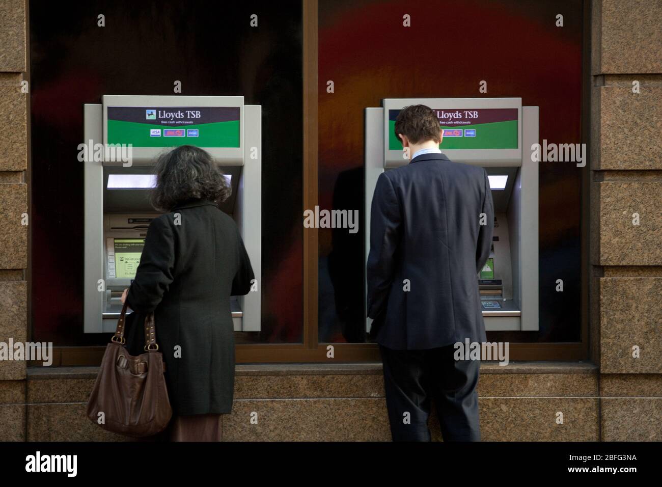 Customers using a Lloyds TSB cash point. Stock Photo