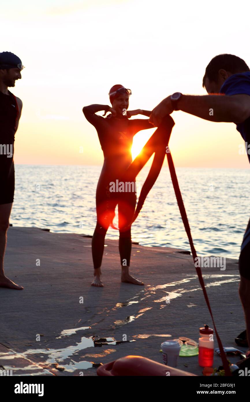 A group of swimmers prepare for an early morning open water swim in