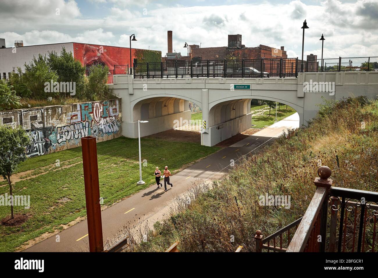 Lone young couple jogging on the Dequindre Cut Greenway in Eastern Market area in Downtown Detroit, Michigan USA Stock Photo