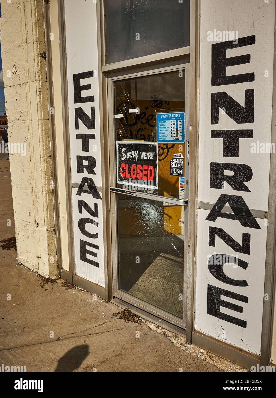 Store entrance with 'Sorry We're Closed' sign and broken glass Stock Photo