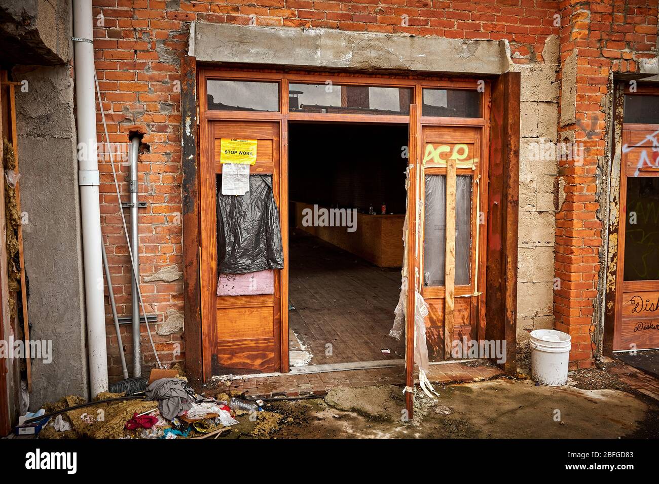 Detroit vacant store shop entrance with work stop order posted. Graffiti and vandalism in view. Stock Photo