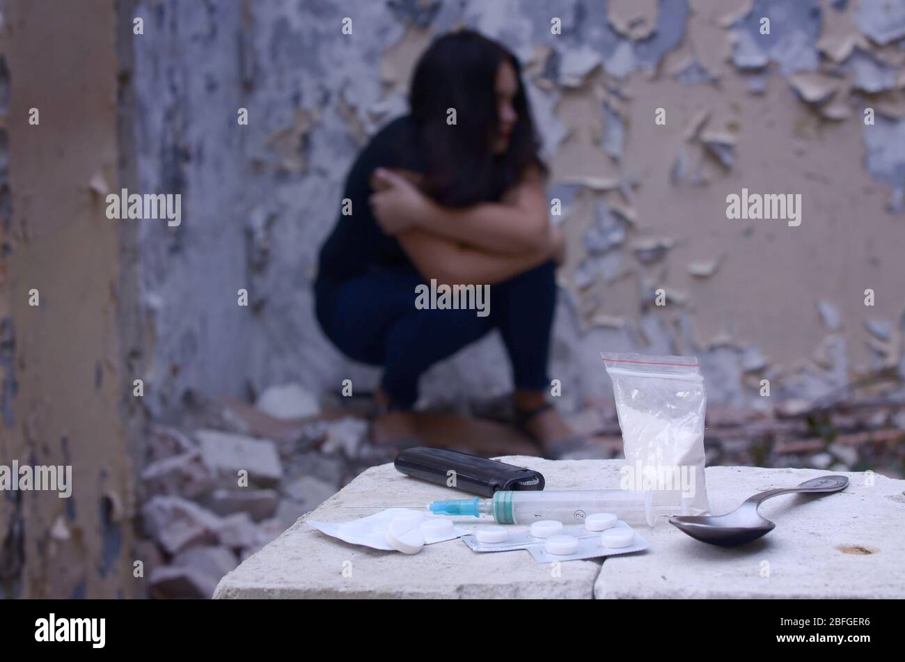 Young woman in despair suffers from narcotic effects next to packs of ...