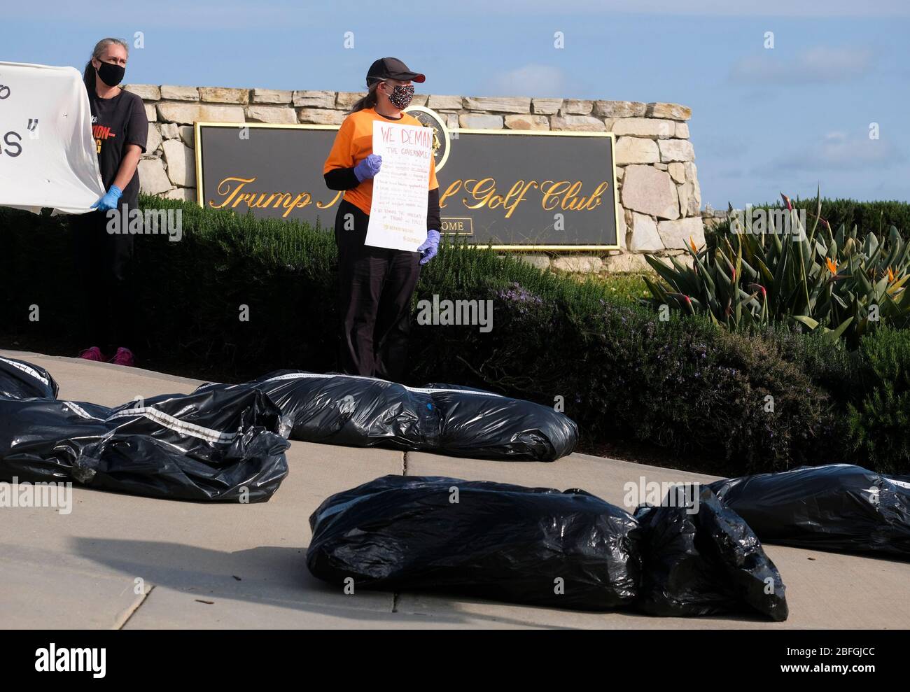 Los Angeles, California, USA. 18th Apr, 2020. Demonstrators stand as fake body bags are placed at outside Trump National Golf Club Los Angeles in protest against U.S. President Donald Trump's response to the coronavirus disease (COVID-19) pandemic, in Rancho Palos Verdes, California, April 18, 2020. Credit: Ringo Chiu/ZUMA Wire/Alamy Live News Stock Photo