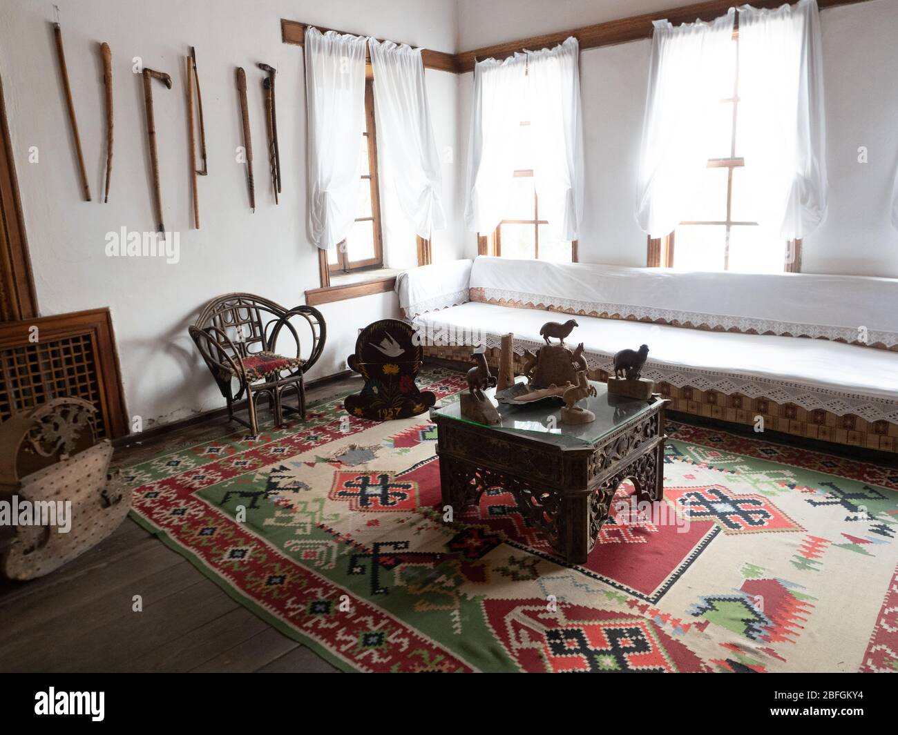 Room in the Ethnographic Museum in Gjirokaster Albania with carved wooden animal statues, cradles, and canes. Stock Photo