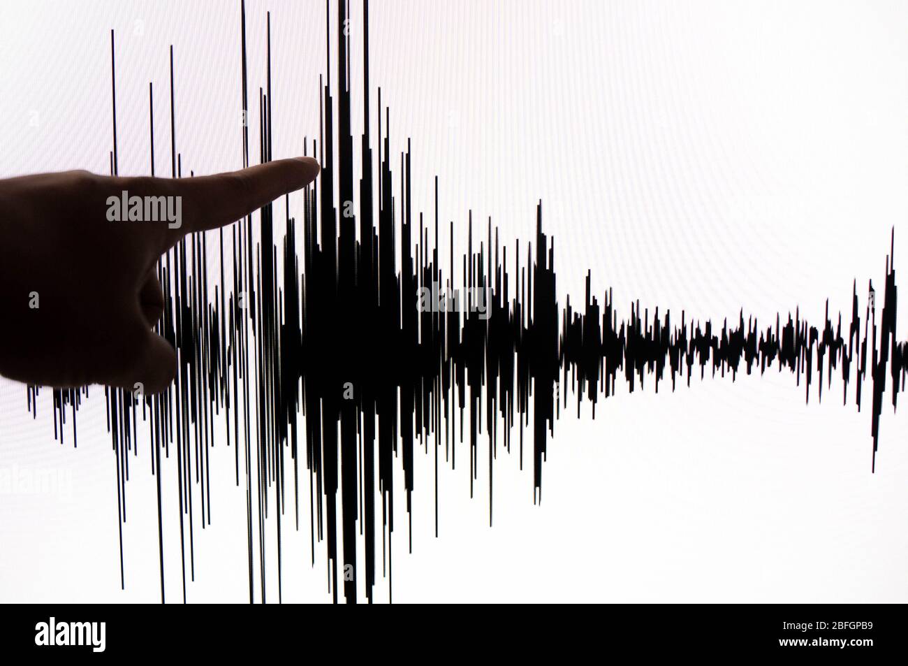 Using Seismograph Photograph of a person using his hand to point on the white screen with ...