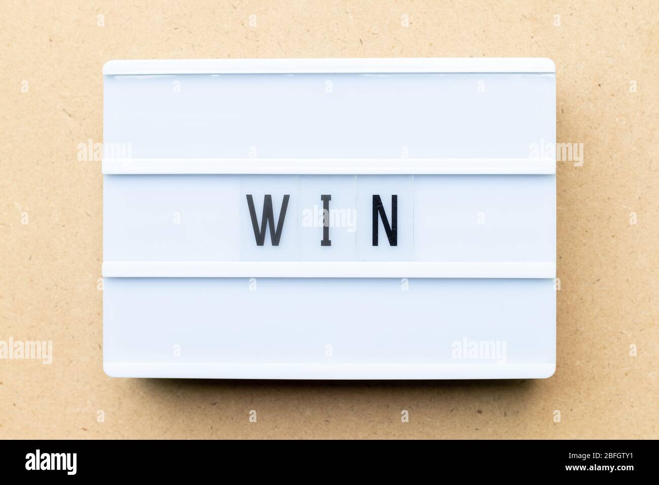 White lightbox with word win on wood background Stock Photo