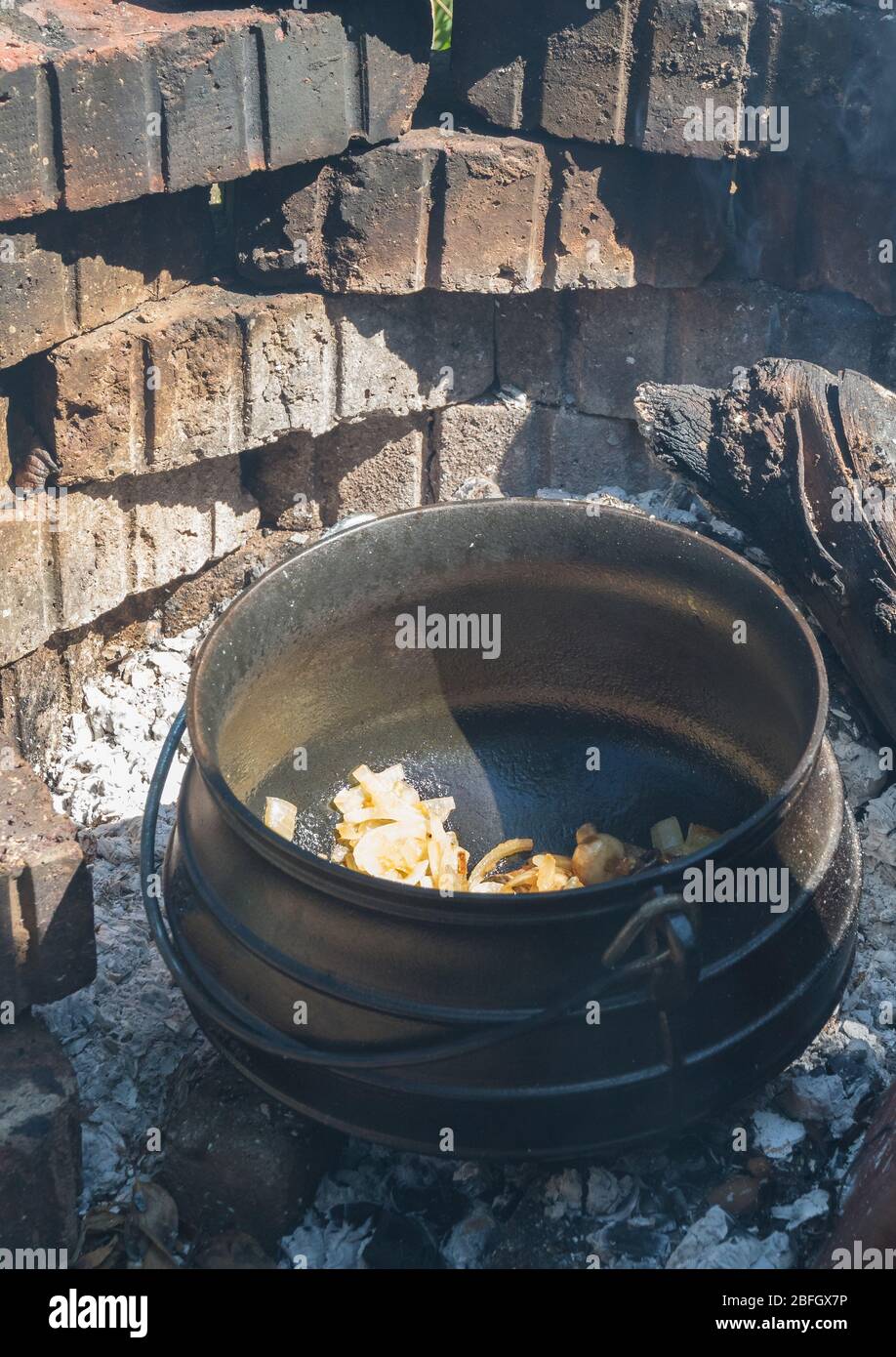 Food prepared outside on an open fire in a cast iron pot traditional