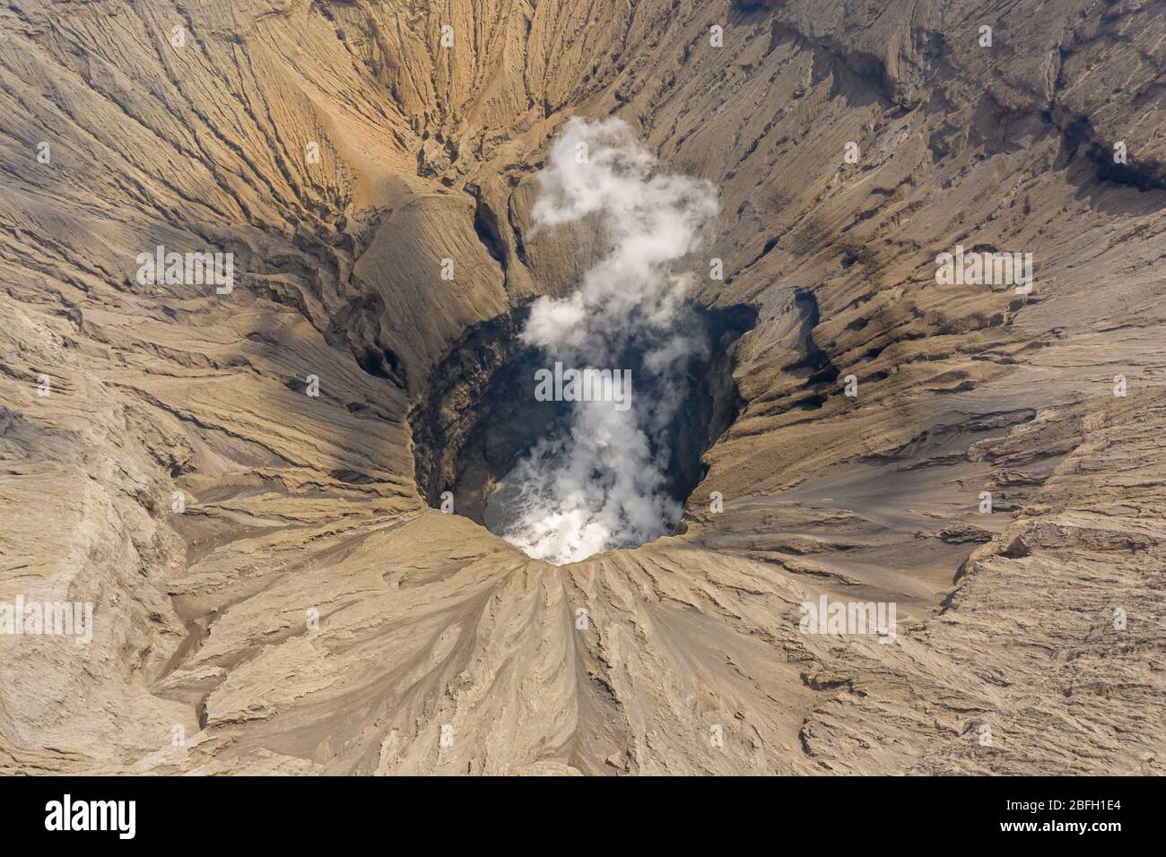 Aerial view of the crater of an active volcano emitting gas and fumes (Mount Bromo, Java) Stock Photo