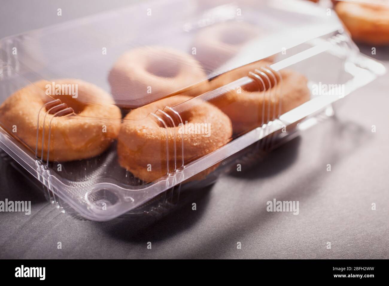 Delicious donuts in a plastic container Stock Photo