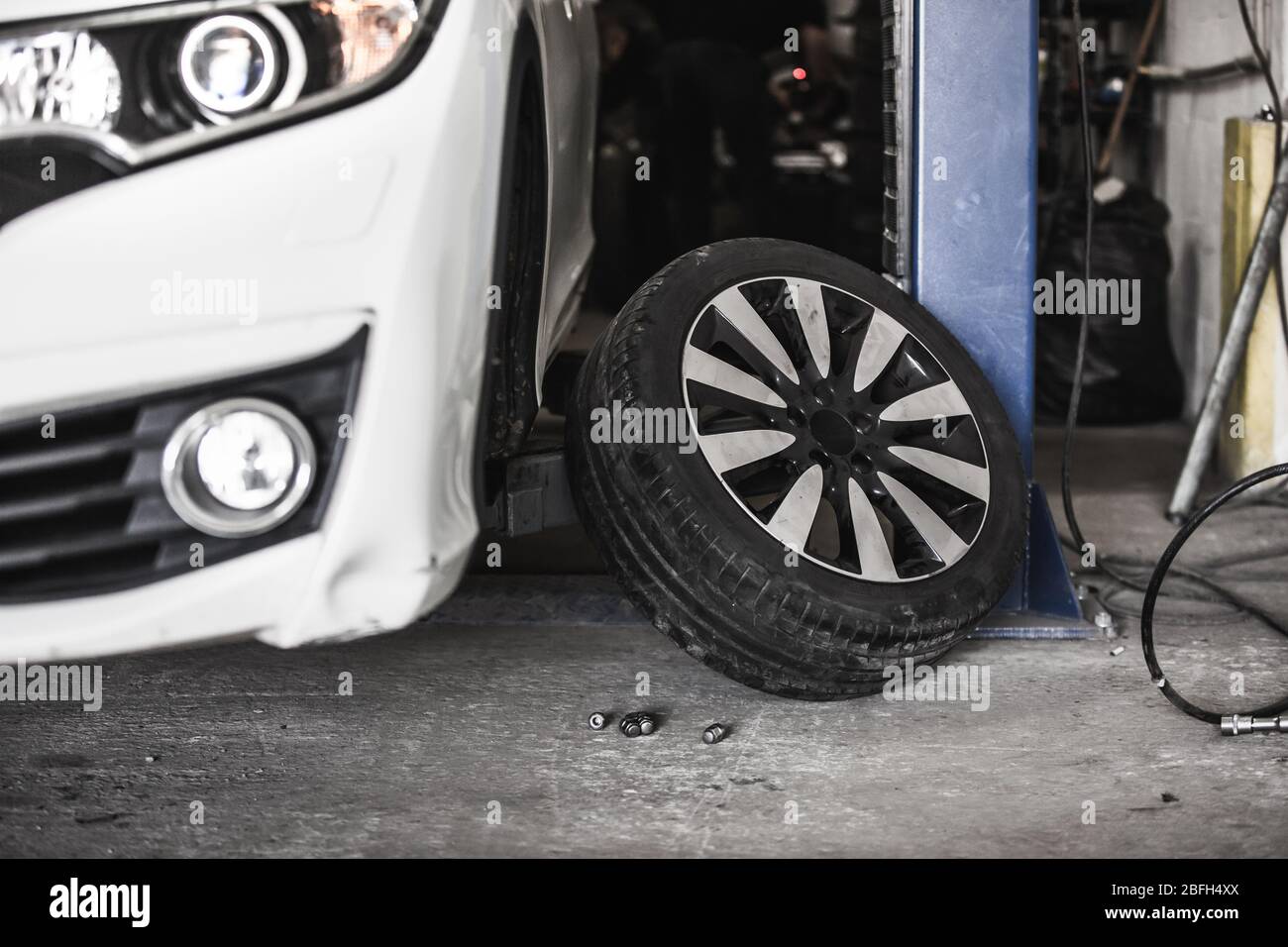 Changing car wheel in auto, car service with lifted vehicle, service