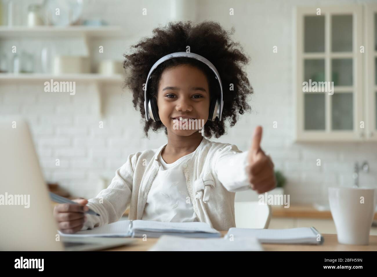 Smiling biracial little girl recommend online course Stock Photo