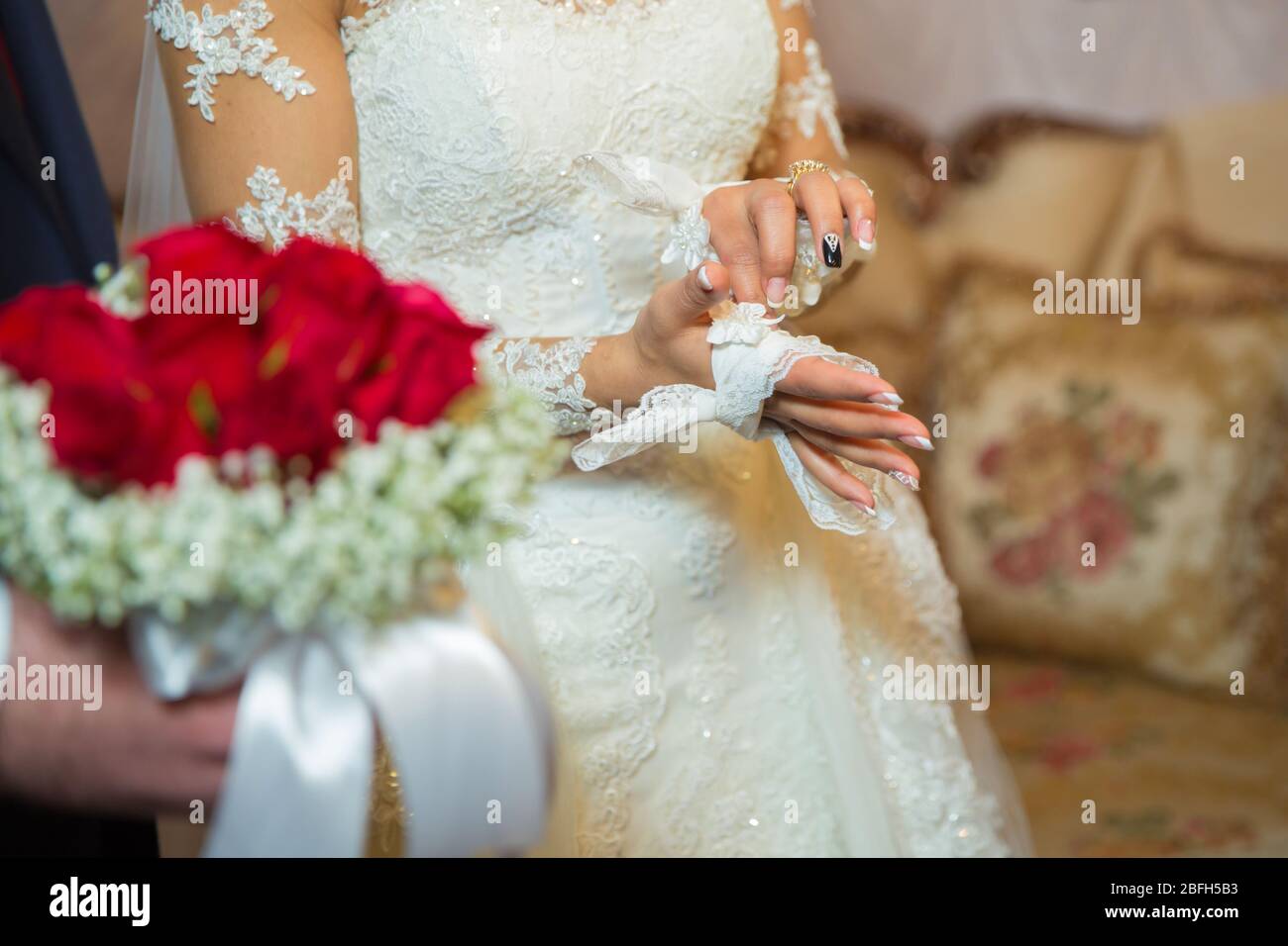 The groom tied a handkerchief in the bride's hand . The bride puts the