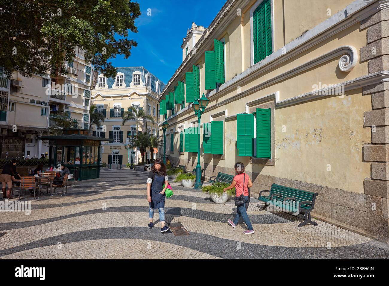 People walking on a narrow pedestrian cobblestone street in the historic district of Macau, China. Stock Photo