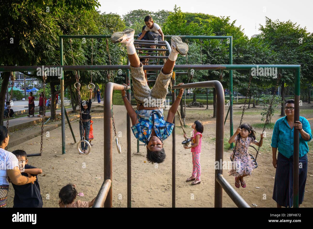 Kids playing on the monkey bars in Mahabandoola Garden, Yangon, Myanmar Stock Photo