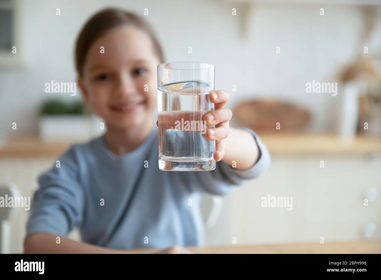 Little girl offer clean mineral water for body refreshment Stock Photo