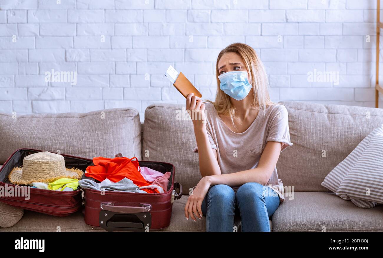 Woman looks at tickets, near open suitcase Stock Photo