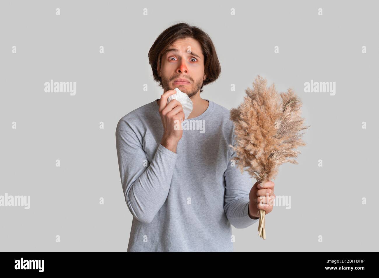 Funny shocked man with red nose, napkin and bouquet Stock Photo