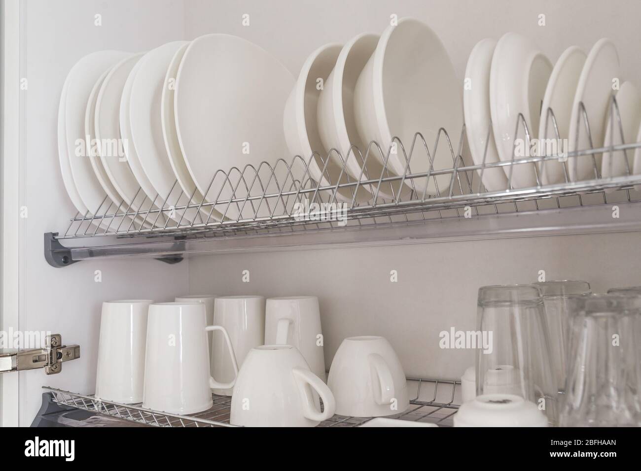 https://c8.alamy.com/comp/2BFHAAN/dish-drying-metal-rack-with-big-nice-white-clean-kitchenware-traditional-wall-cabinet-kitchen-2BFHAAN.jpg