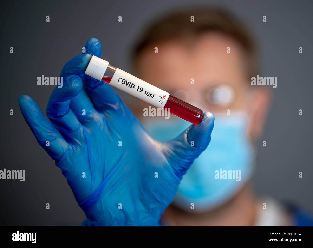 COVID-19. Doctor scientist in Personal Protective Equipment holding vial of blood sample test of infected patient at lab hospital. Coronavirus blood t Stock Photo