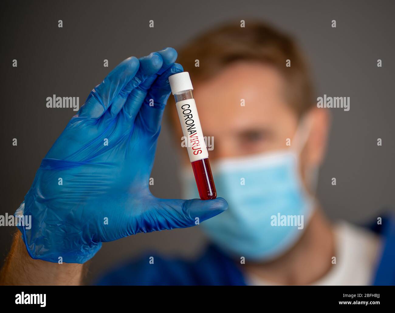 COVID-19. Doctor scientist in Personal Protective Equipment holding vial of blood sample test of infected patient at lab hospital. Coronavirus blood t Stock Photo