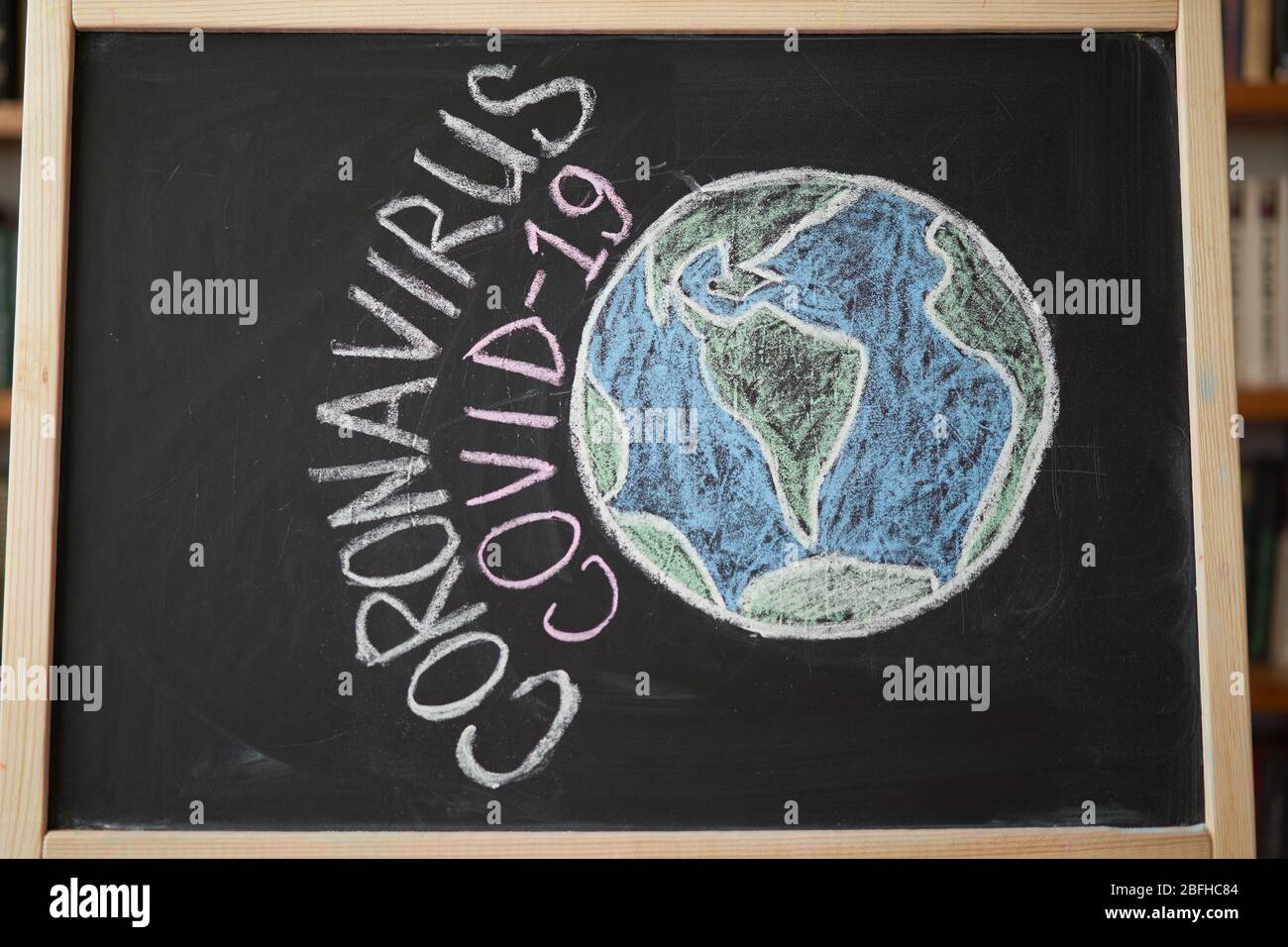 Planet Earth in danger Outbreak Warning. written white chalk on blackboard in connection with epidemic of coronavirus worldwide. Covid 19 pandemic Tex Stock Photo