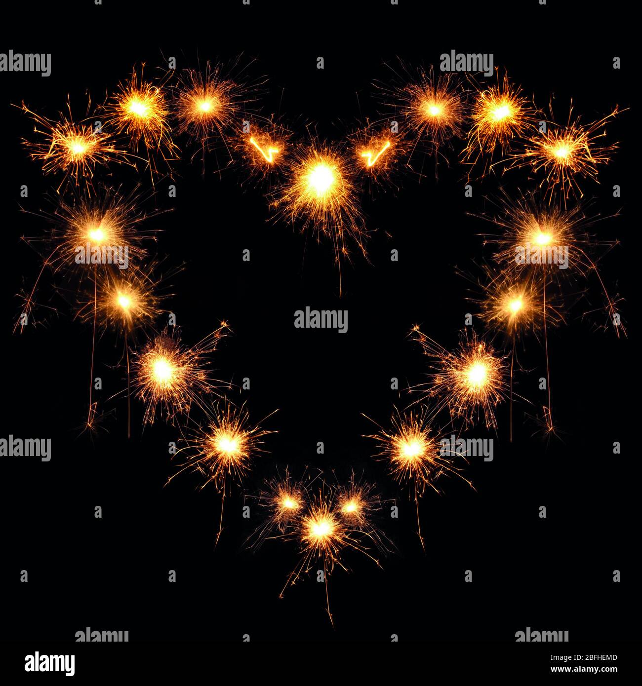heart-shaped sparklers on black background Stock Photo