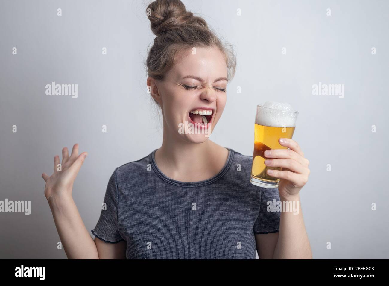 Laughing smiling young caucasian woman girl with glass of beer Stock Photo