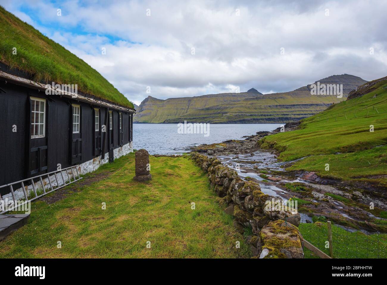 Small wooden village church with a tomb stone in Faroe Islands, Denmark Stock Photo