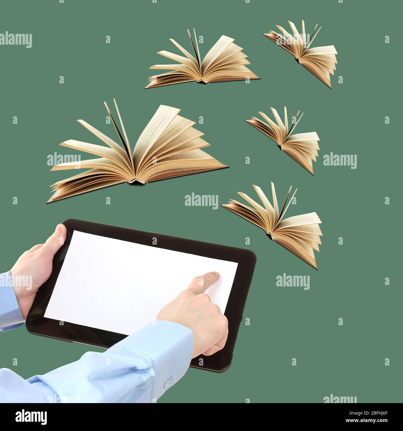 Tablet and opened books on green background Stock Photo