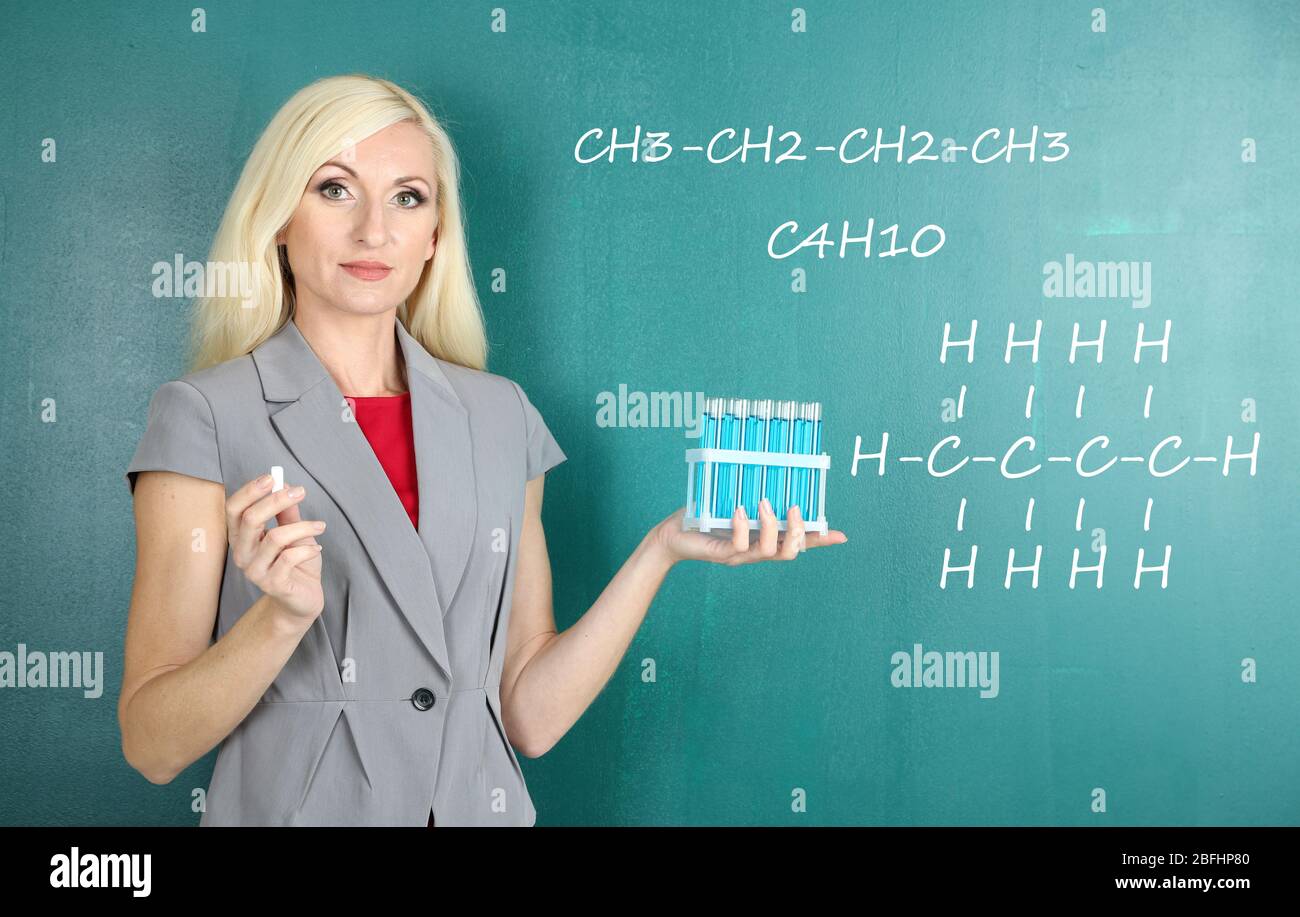 Chemistry Teacher Explaining Formula Written On Blackboard To Her ...